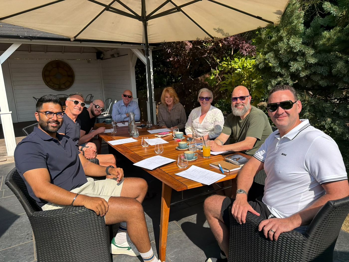 Members around a table outdoors in the sunshine