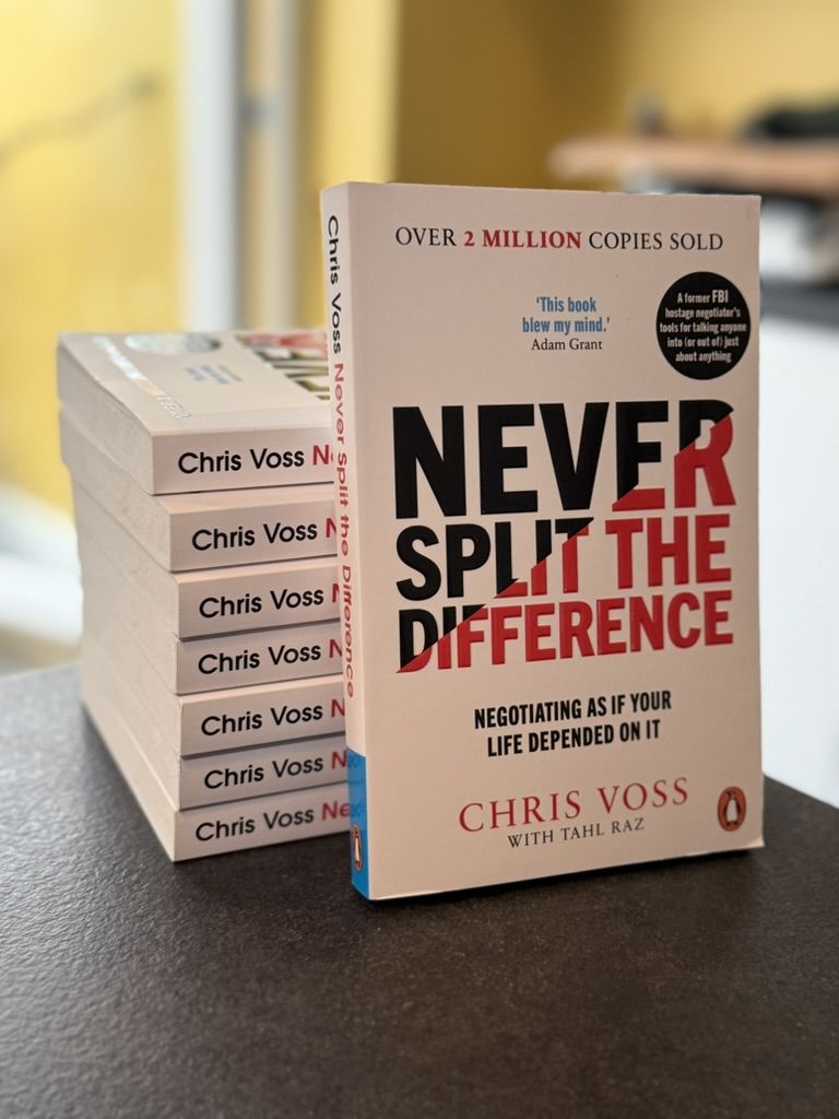 A stack of copies of Never Split the Difference by Chris Voss